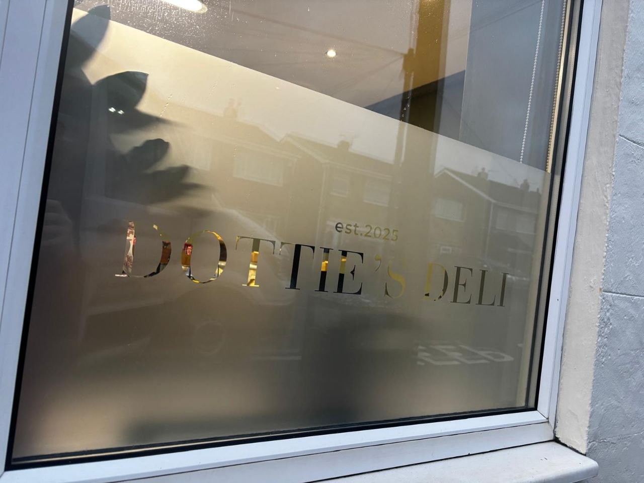 Close-up of gold cut vinyl lettering on Dottie's Deli window